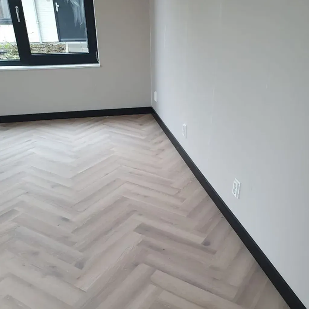 Moldura decorativa de metal negro con borde ranurado sobre fondo blanco.