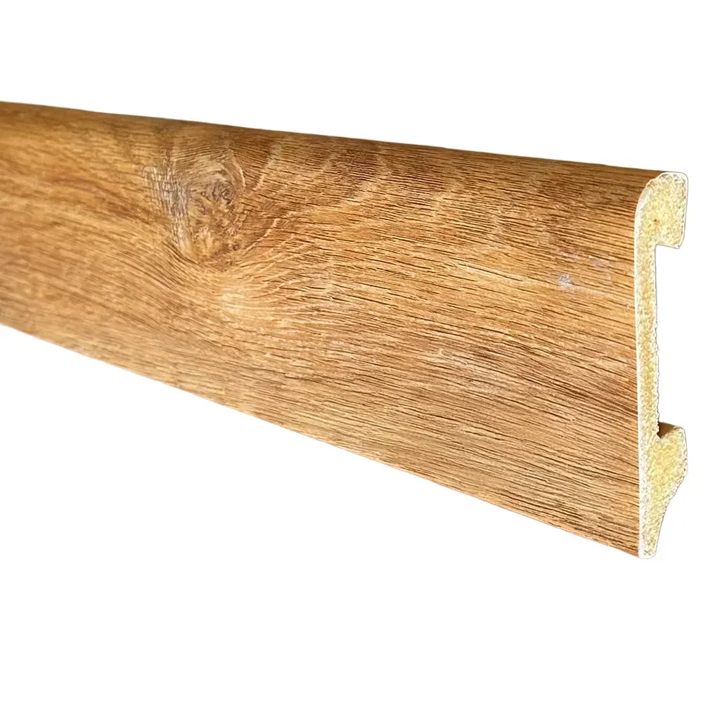 Moldura de zócalo de madera con vetas de madera y perfil dentado sobre fondo blanco.