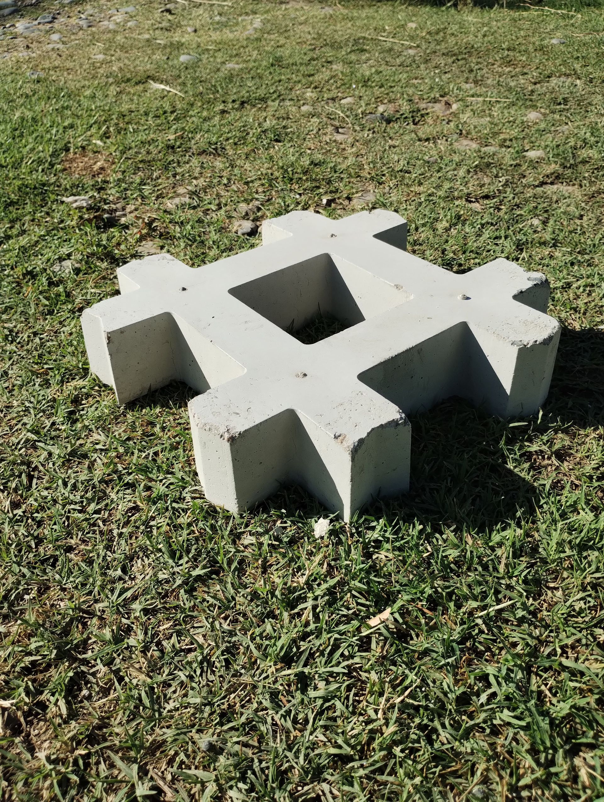Bloque de hormigón blanco con dos aberturas cuadradas sobre césped al aire libre