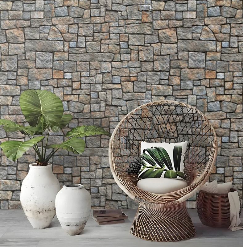 Silla de mimbre con cojín a rayas contra una pared de piedra, flanqueada por jarrones blancos y plantas en macetas.