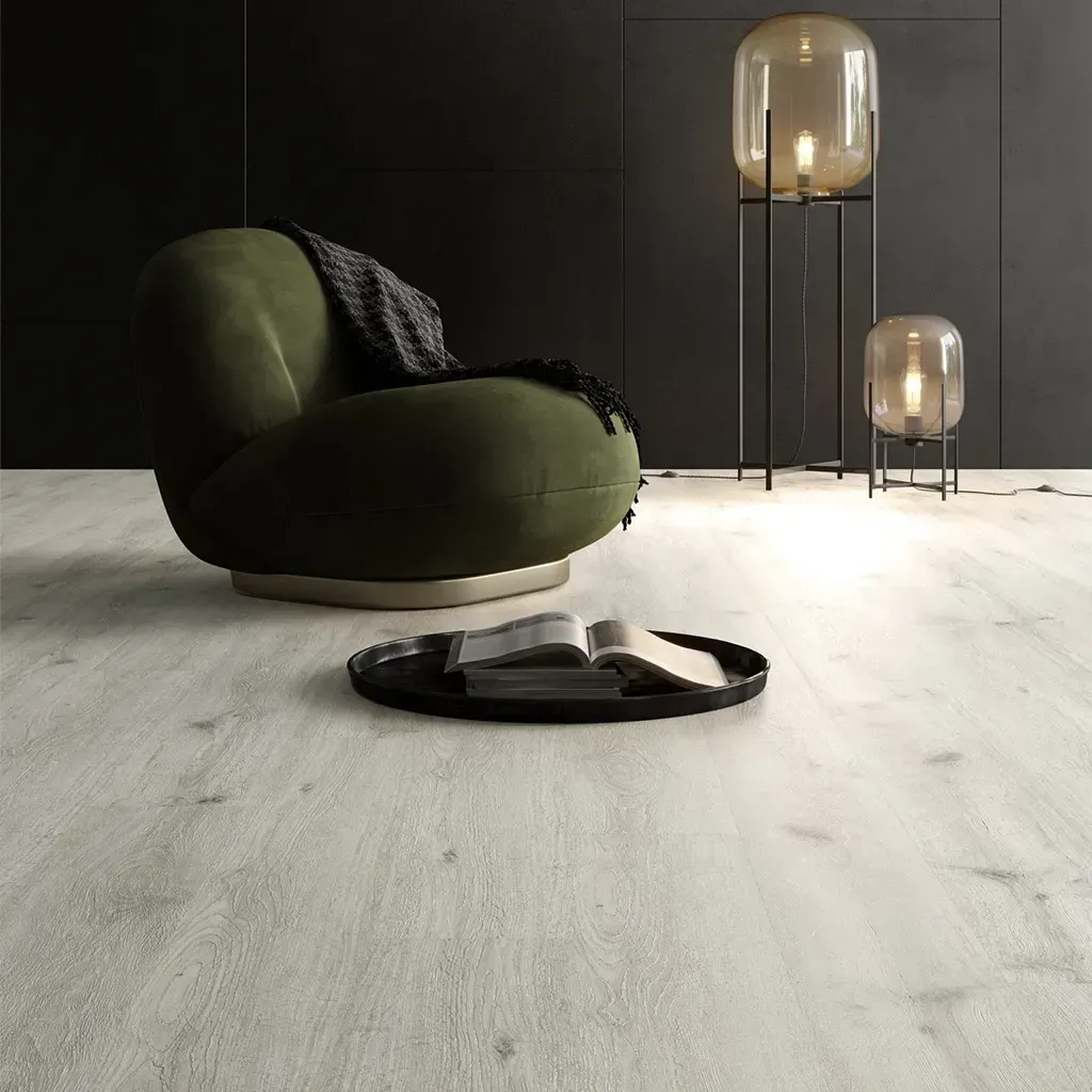 Sala de estar moderna con sillón verde, mesa auxiliar redonda y lámparas de pie altas de cristal