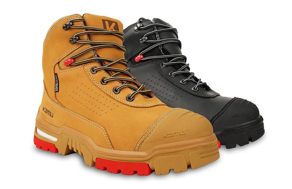 A pair of black and tan safety boots on a white background.