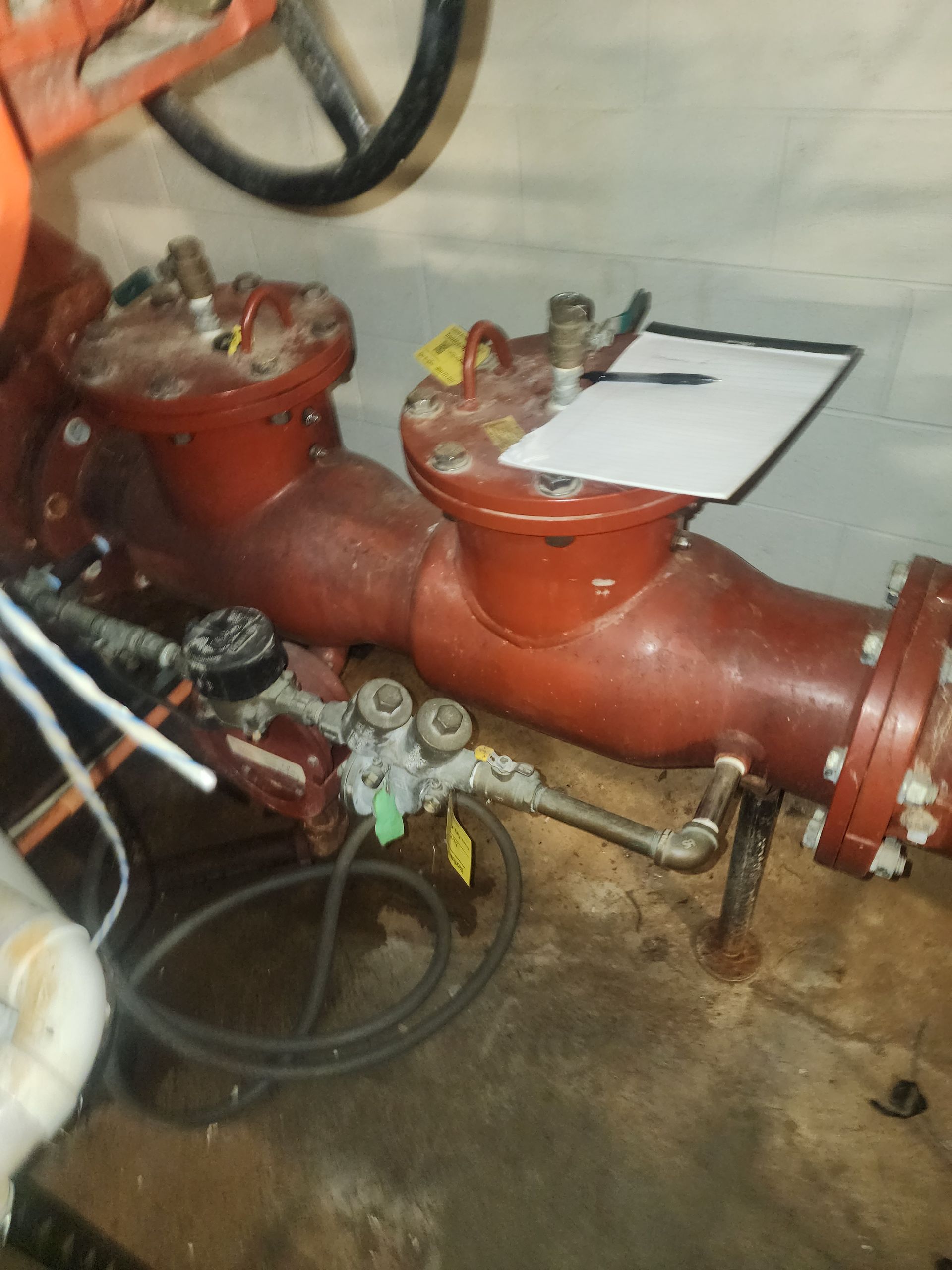 a red pipe with a clipboard on top of it