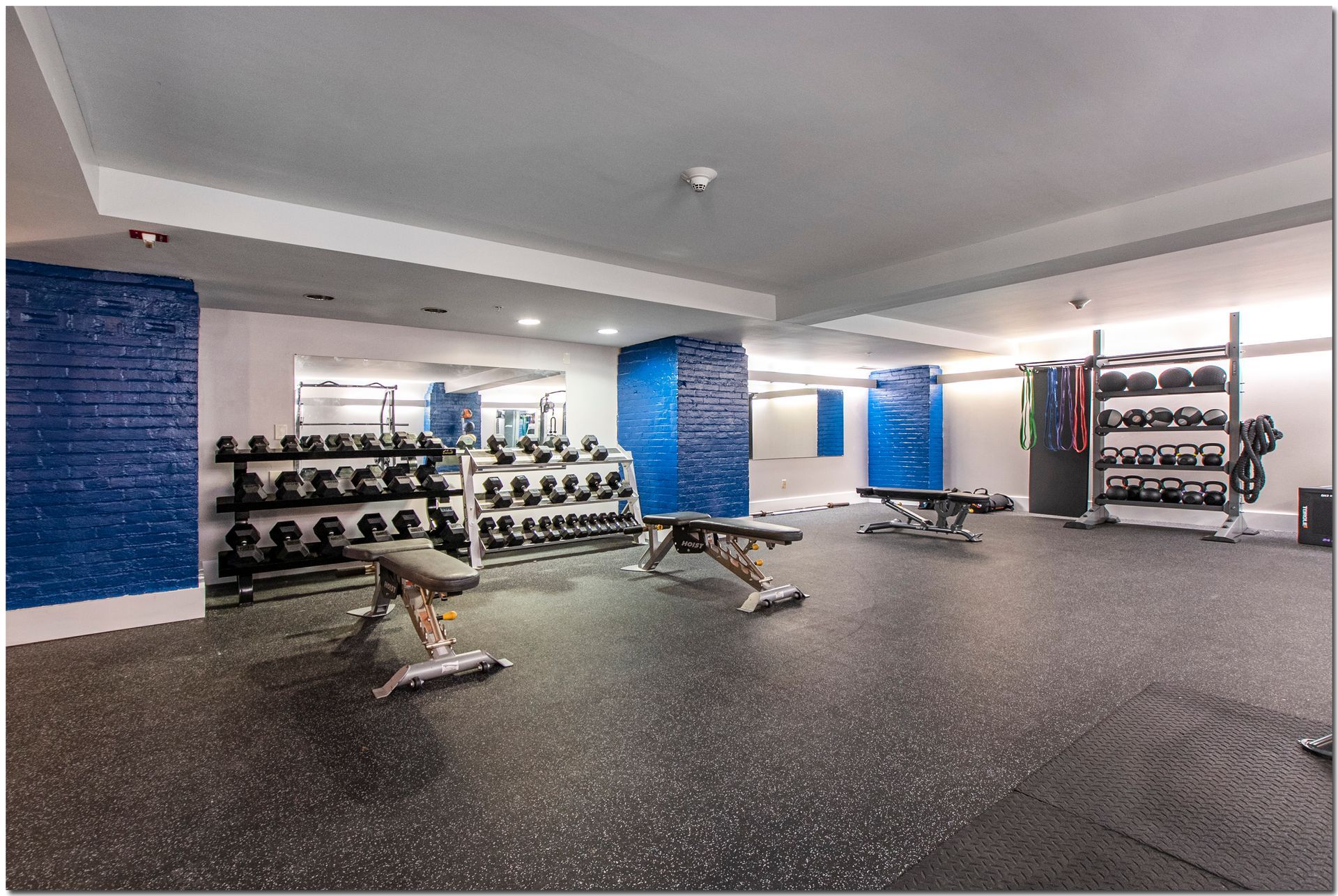 A gym with a lot of dumbbells and benches