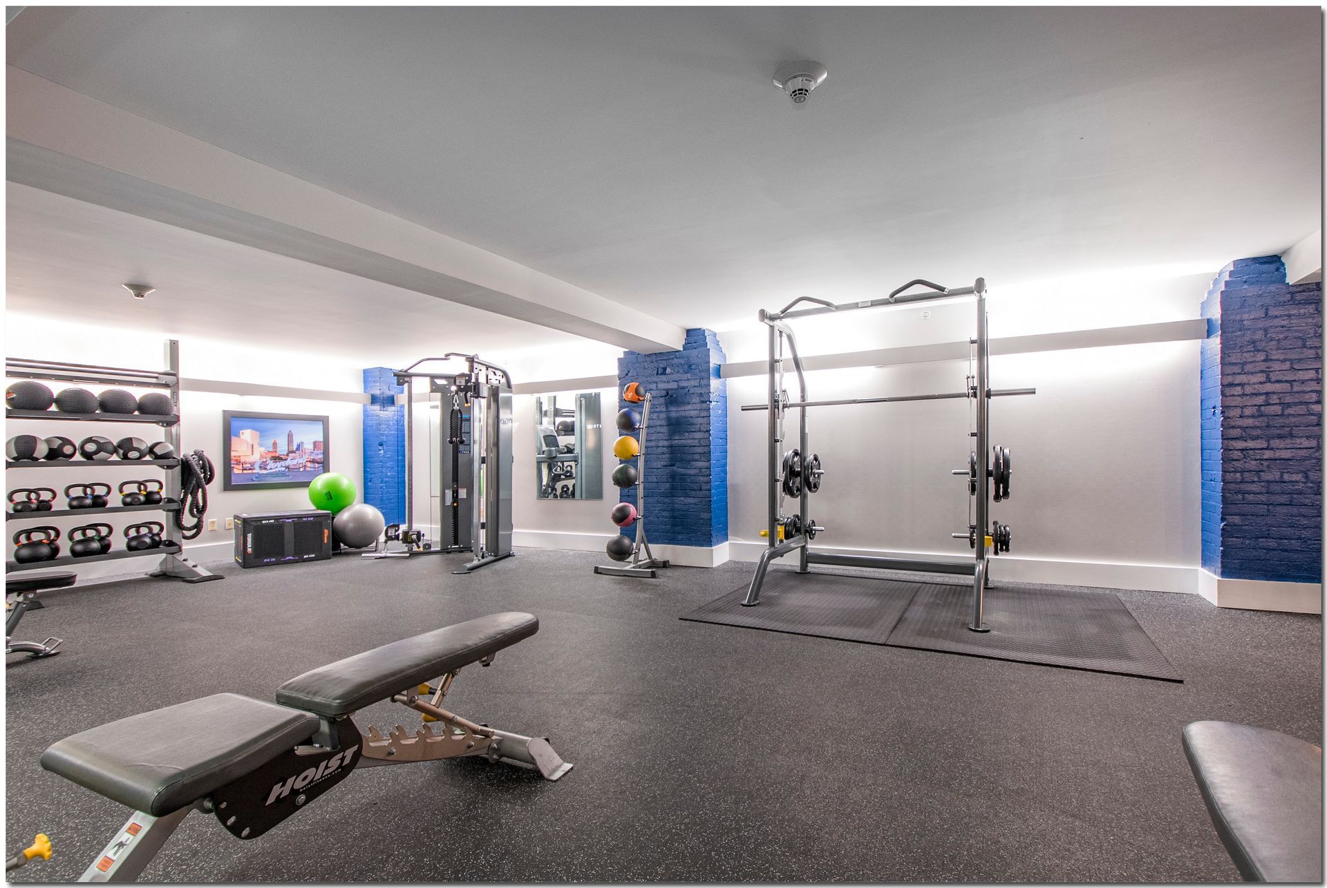 A large gym with a lot of equipment and a bench.