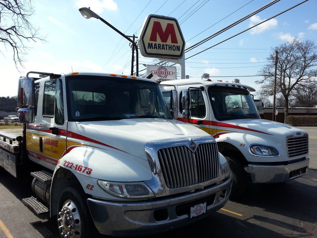Two tow trucks are parked in front of a mcdonald 's