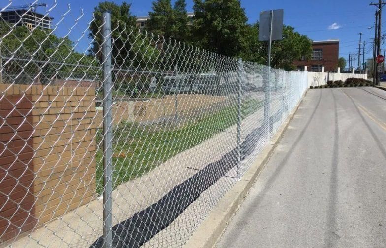 A chain link fence along the side of a road
