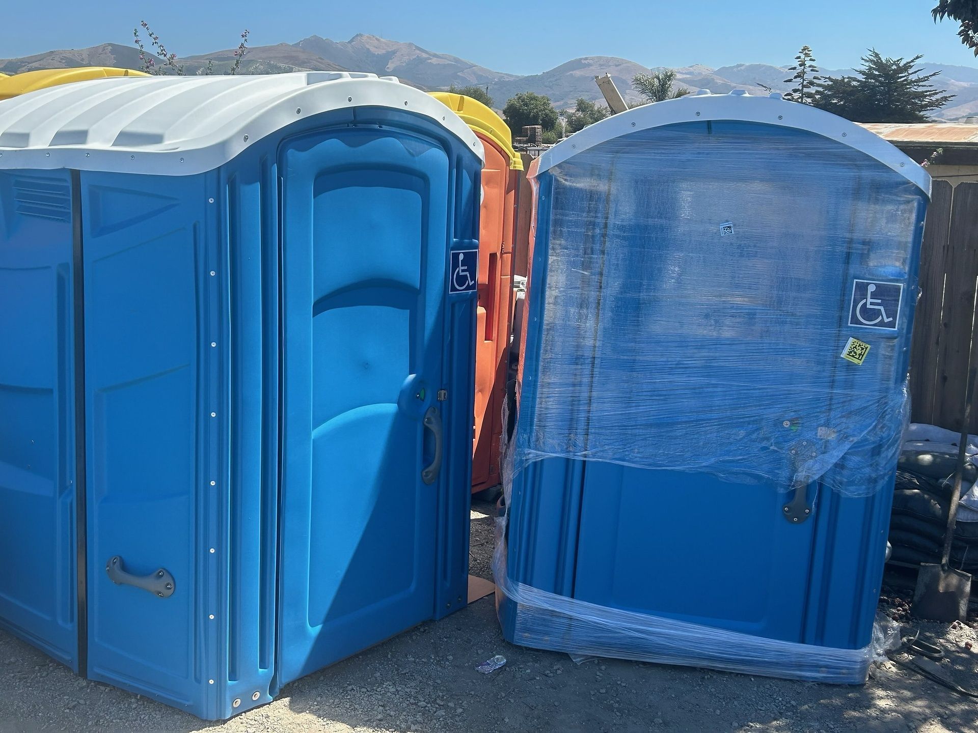 Two blue portable toilets are sitting next to each other