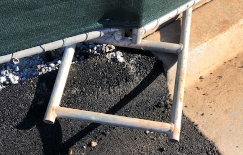 A chair is sitting on the side of the road next to a concrete curb.