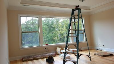Interior room with open window, ladder, and construction materials on the floor.
