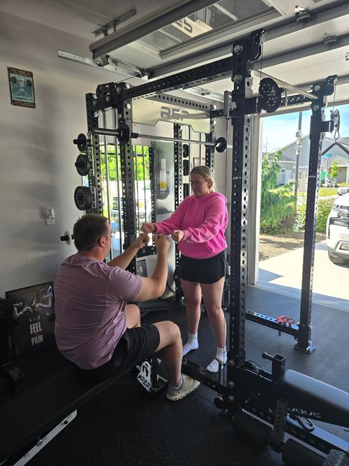 Person in boxing gloves practicing with trainer in a gym.