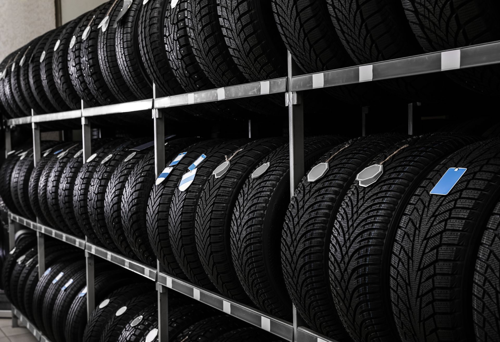 Rows of black tires stacked on metal shelves in a warehouse
