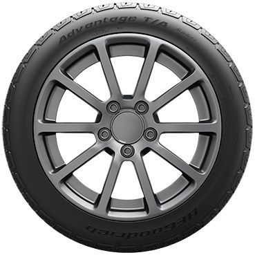 Black car tire mounted on a gray alloy wheel, isolated on a white background