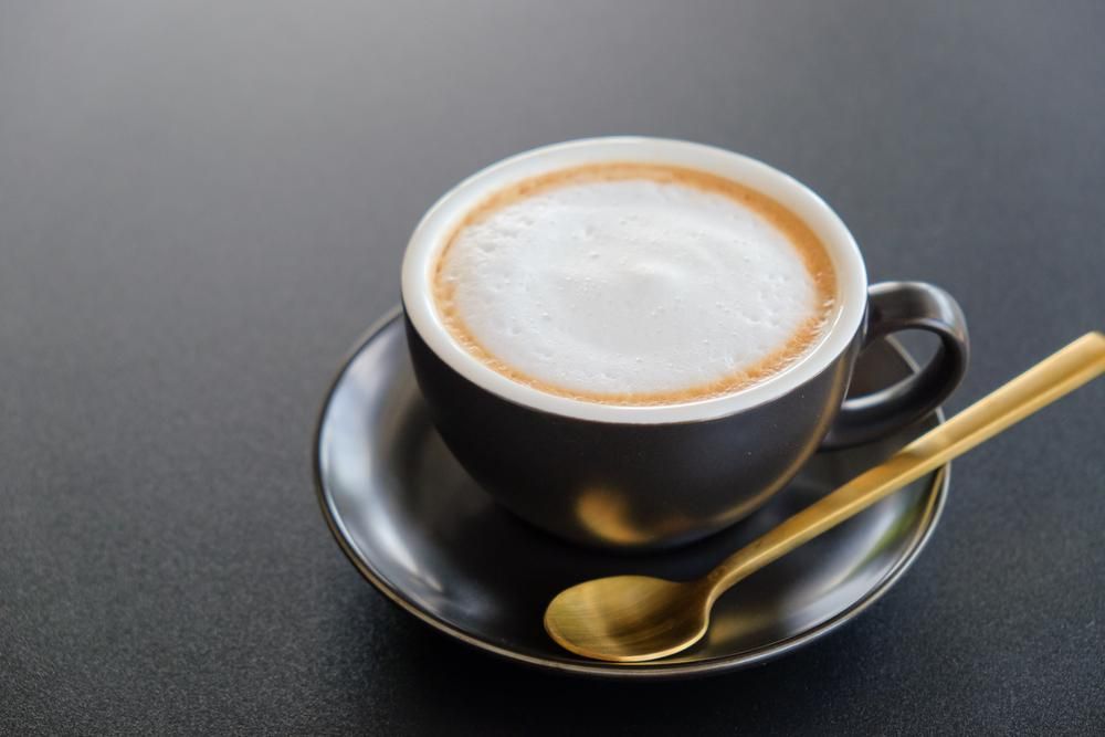 A Black Cup of Cappuccino on A Saucer — Relax in Paradise in Yeppoon, QLD
