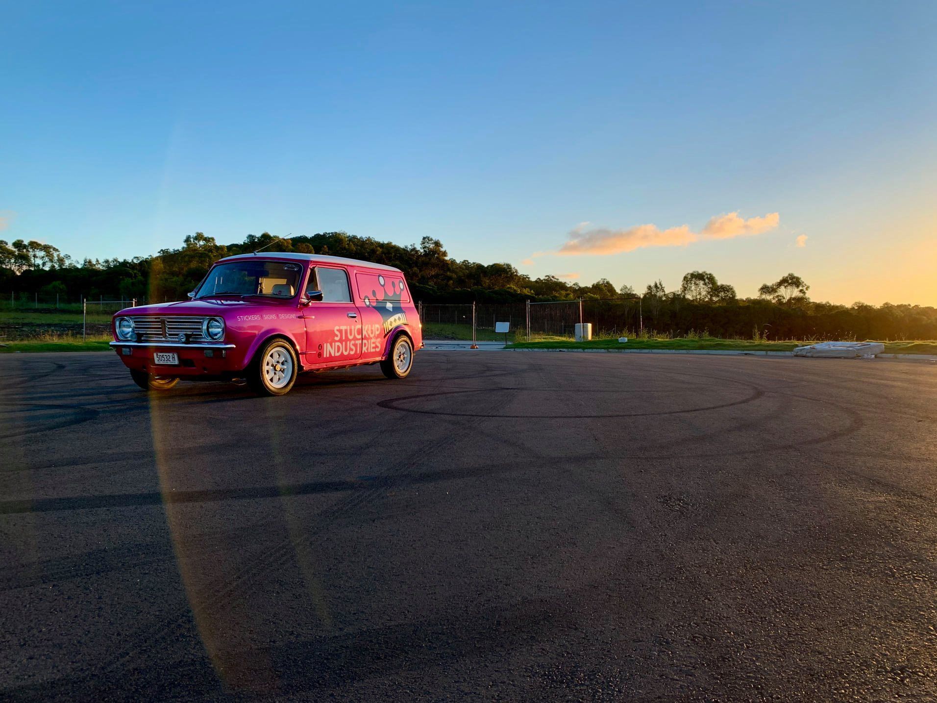 Pink Car Parked on A Paved Area at Sunset with Trees in The Background — Stuckup Industries in Morisset, NSW