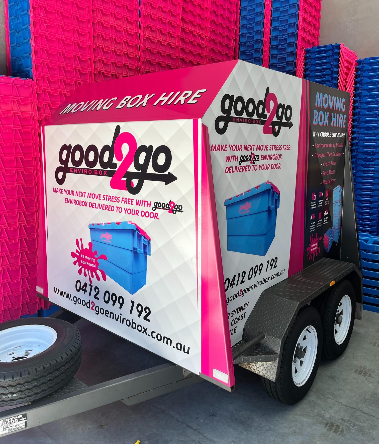 Good2Go moving box hire trailer, pink and blue boxes stacked around it — Stuckup Industries in Morisset, NSW