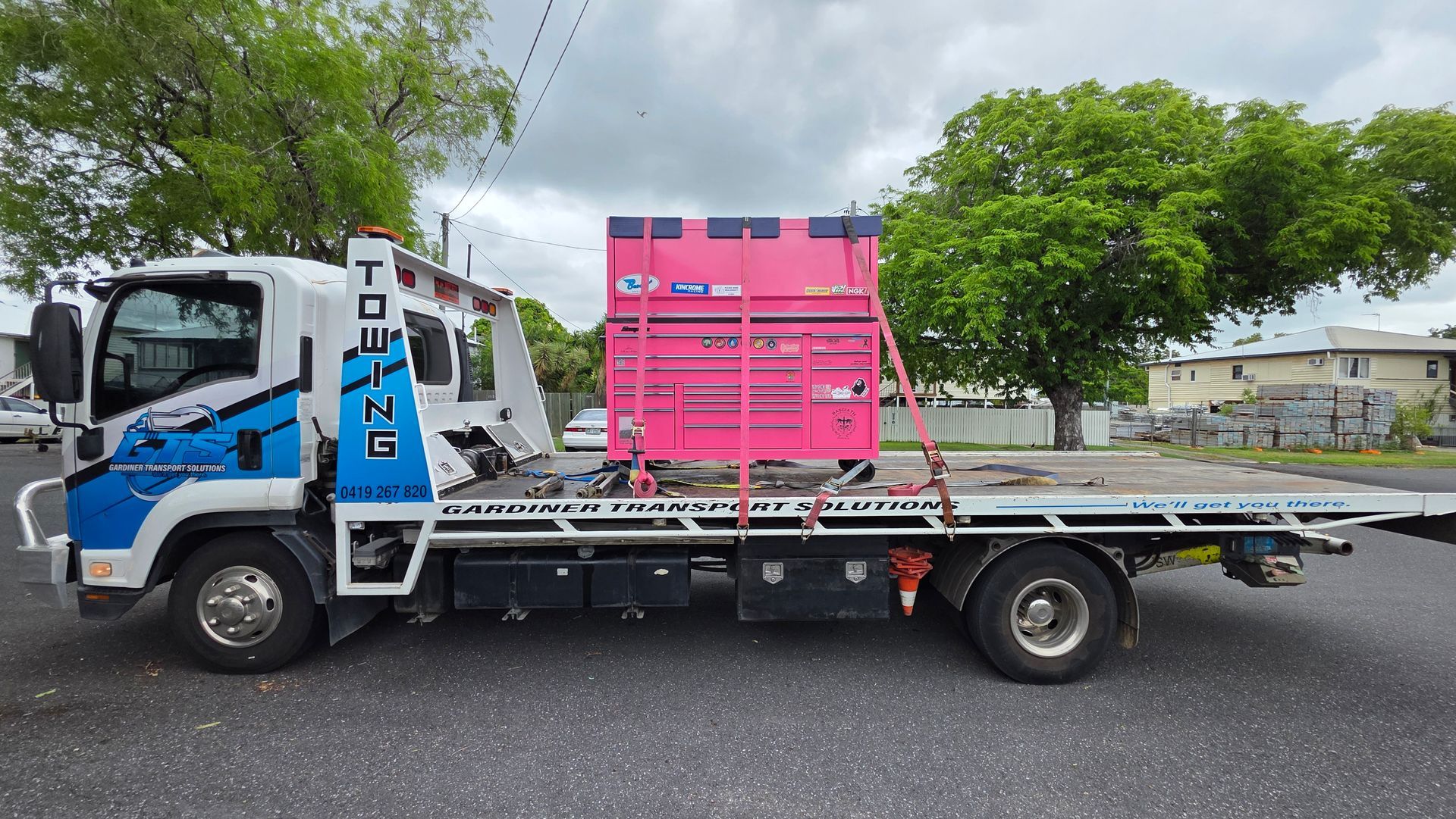 Tow truck carrying a large pink container on a city street — GTS - Gardiner Transport Solutions in Berserker, QLD
