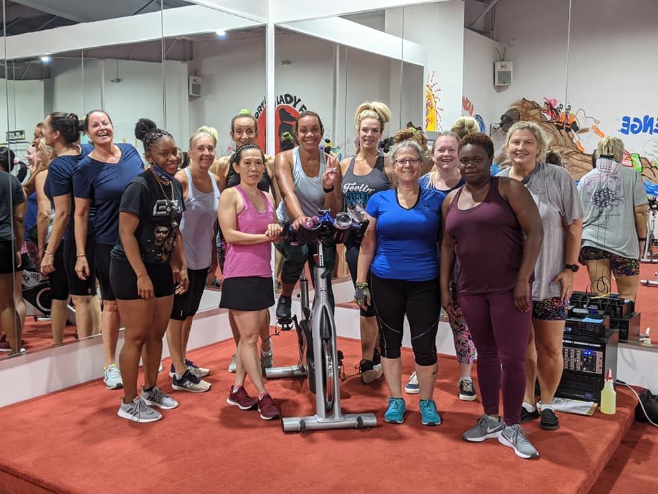 A group of women are posing for a picture in a gym.