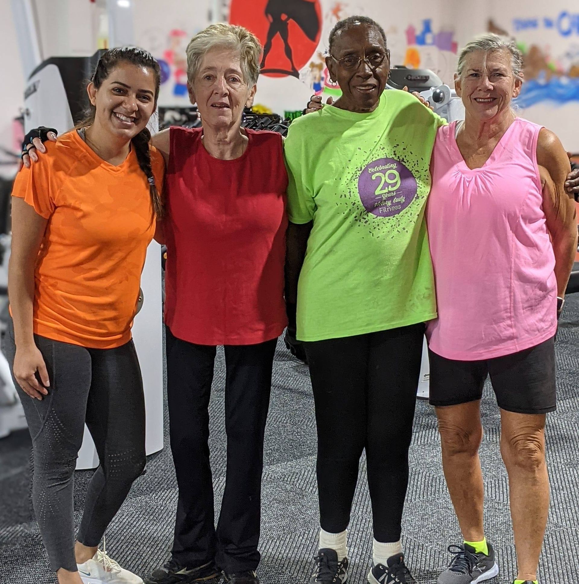 A group of women are posing for a picture in a gym.