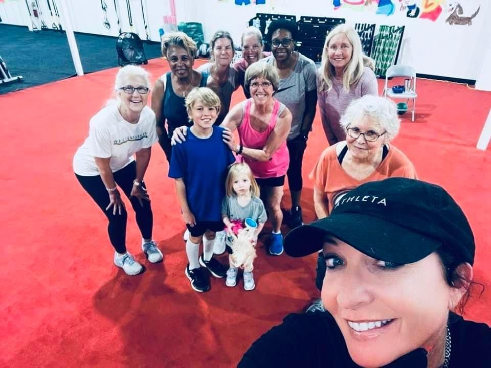 A group of people are posing for a picture in a gym.