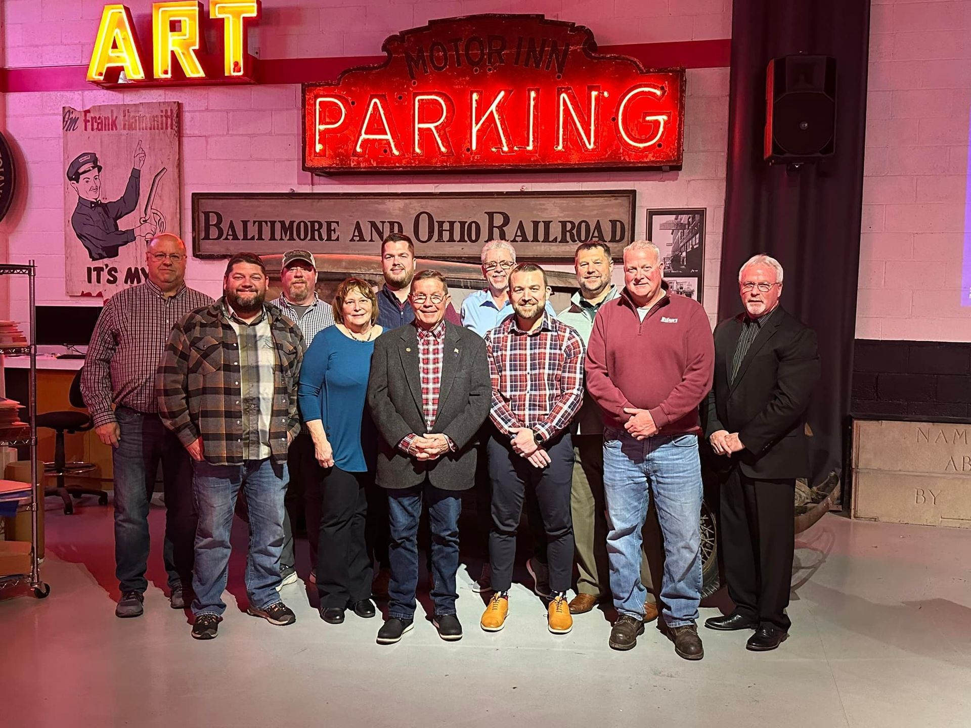 A group of people are posing for a picture in front of a sign that says parking.