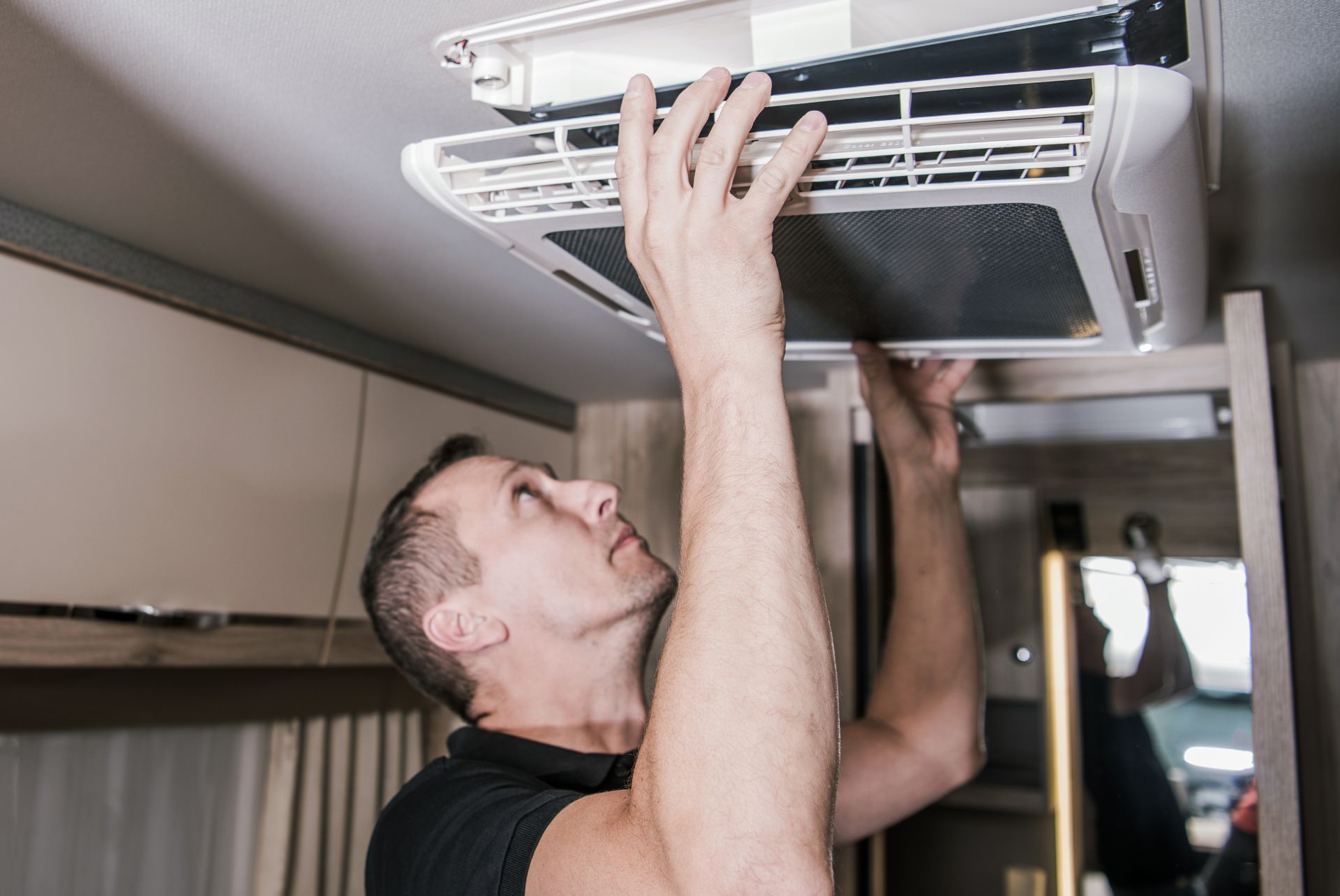 Technician performing RV repair on a motorhome at a full-service RV shop