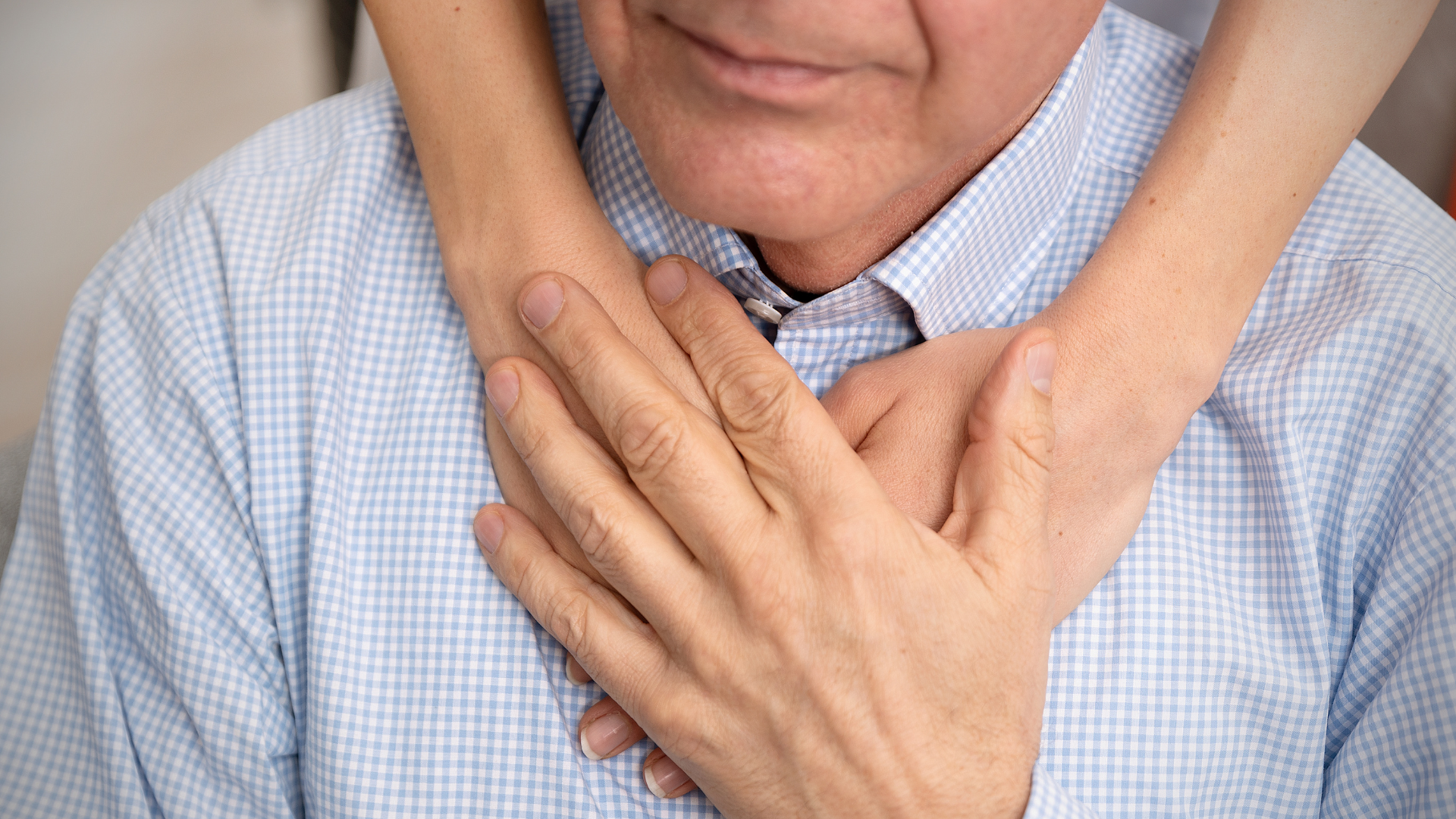 Person with hands on chest, appearing to clutch their heart in discomfort.