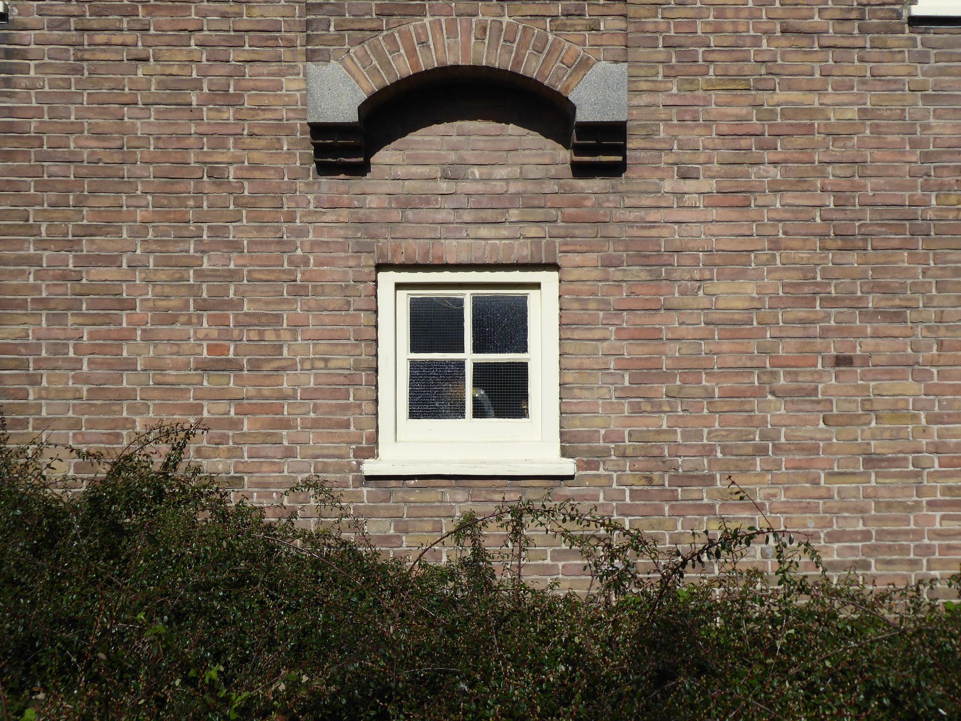 Un bâtiment en briques rouges avec une clôture en bois devant.