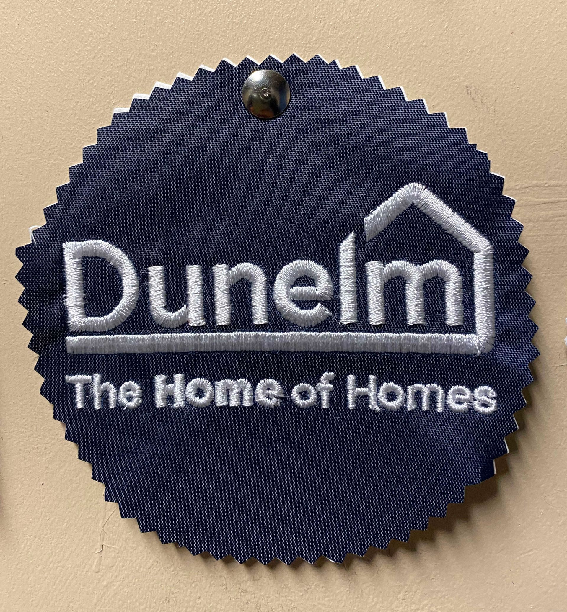 Dark blue Dunelm tag with white embroidered logo and the tagline 