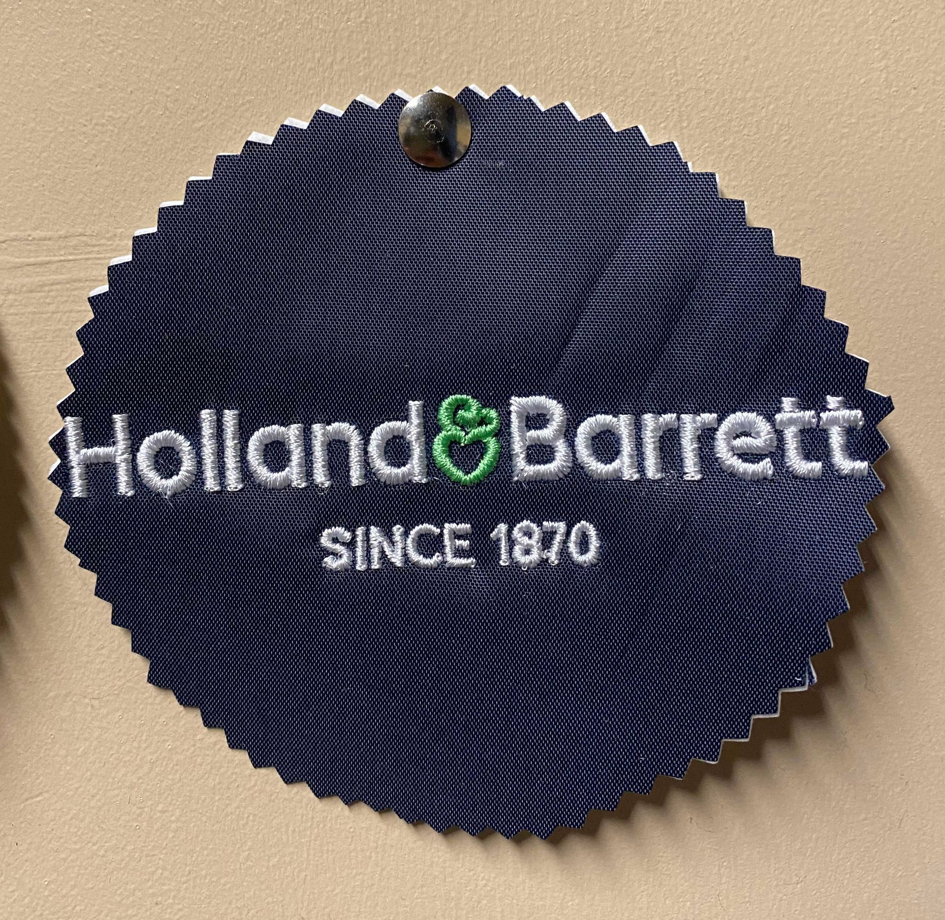 Holland & Barrett logo embroidered white text and a 