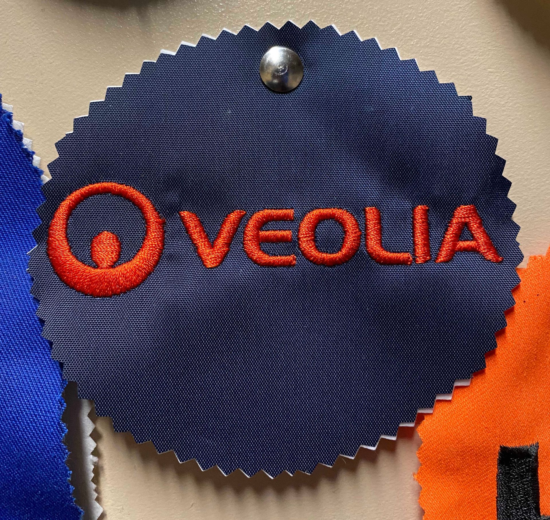 Navy blue fabric swatch with embroidered orange 