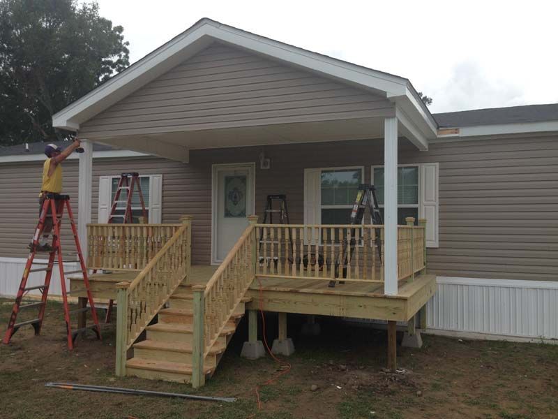 Small house with a front porch and wooden accessibility ramp under construction
