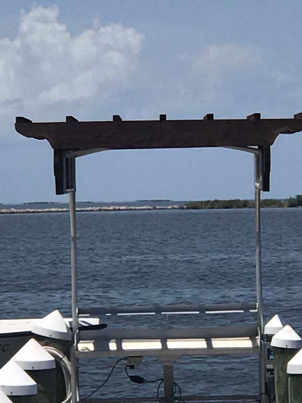 Boat dock roof facing open water under a cloudy sky