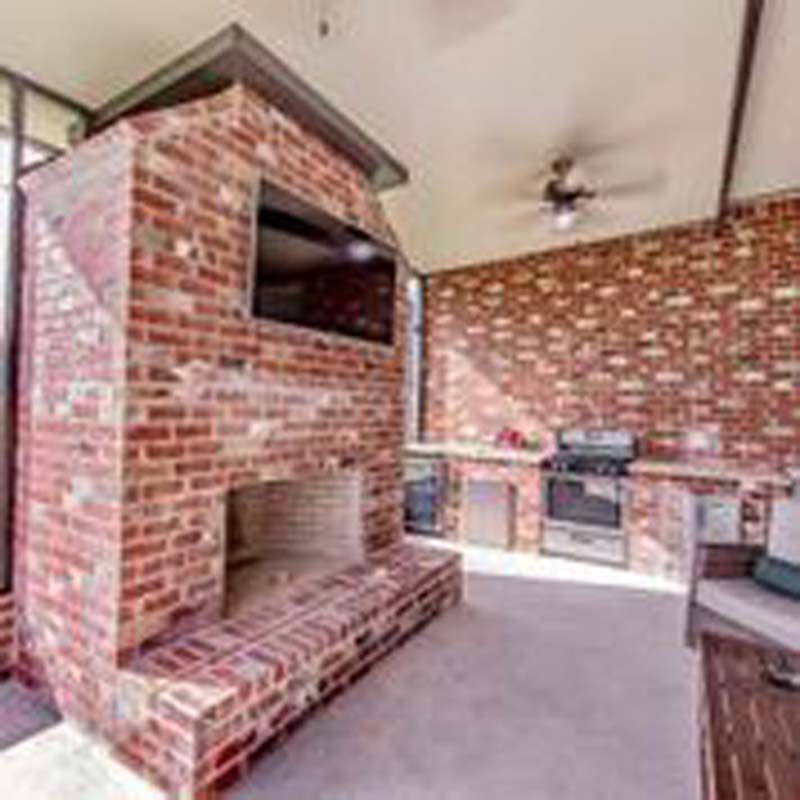 Brick living room with built-in fireplace, TV nook, and brick accent walls