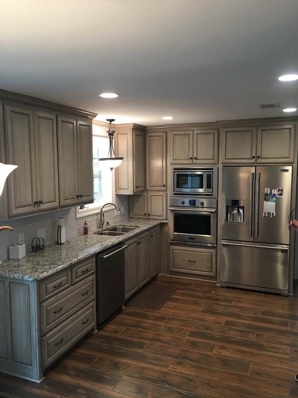 Modern kitchen with wood cabinets, stainless steel appliances, granite counters, and hardwood floors