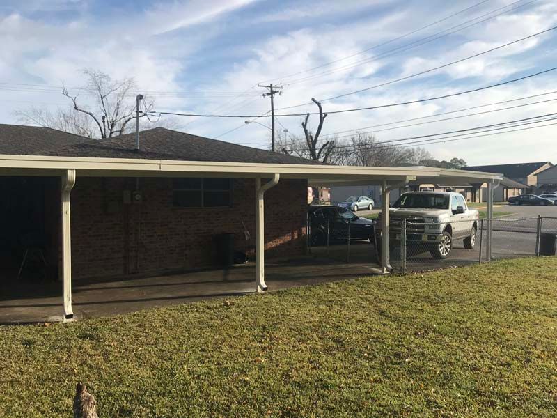 Single-story brick house with carport and a white pickup truck parked in front of it