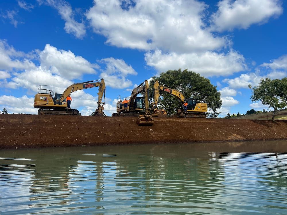 Two Excavators Are Working On A Bridge Over A Body Of Water — J & M Bashforth & Sons In Brunswick Heads, NSW