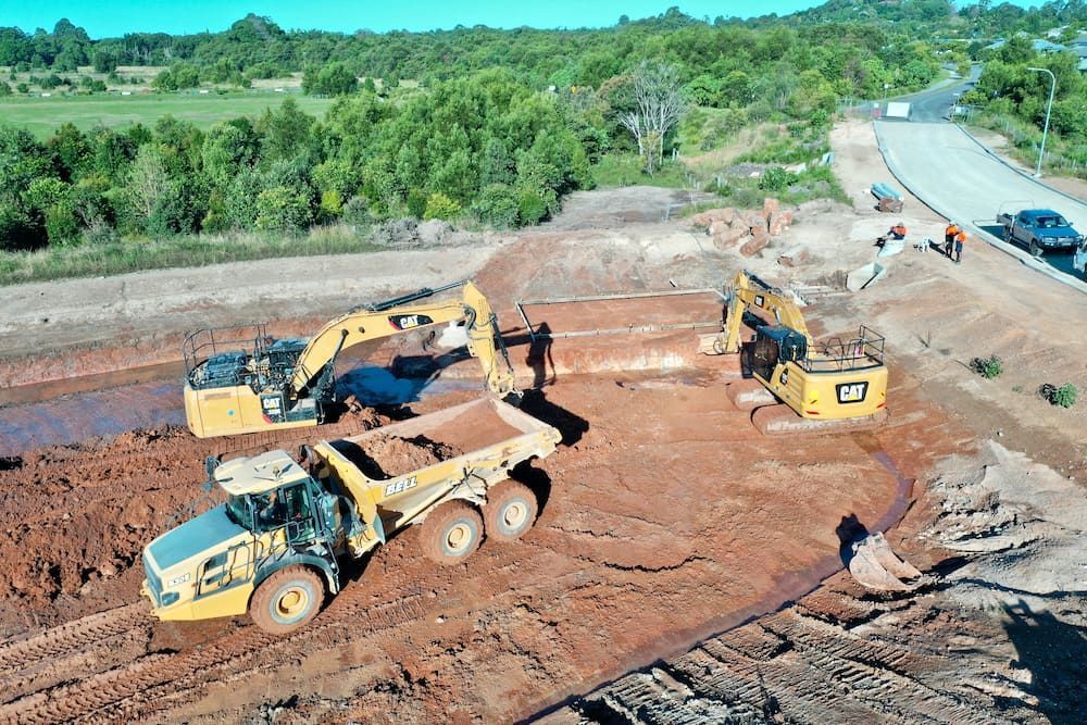 A Group of Construction Vehicles Are Working on A Dirt Road — J & M Bashforth & Sons In Lennox Head, NSW