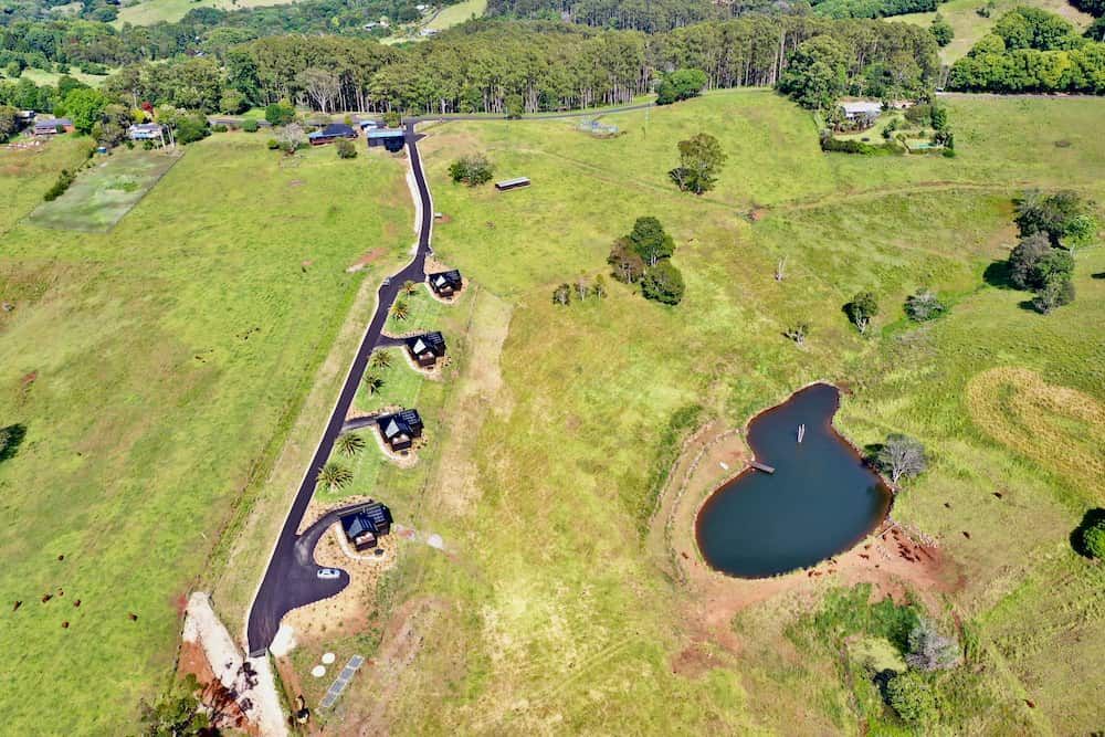 An Aerial View Of A Lush Green Field With A Small Pond In The Middle — J & M Bashforth & Sons In Brunswick Heads, NSW