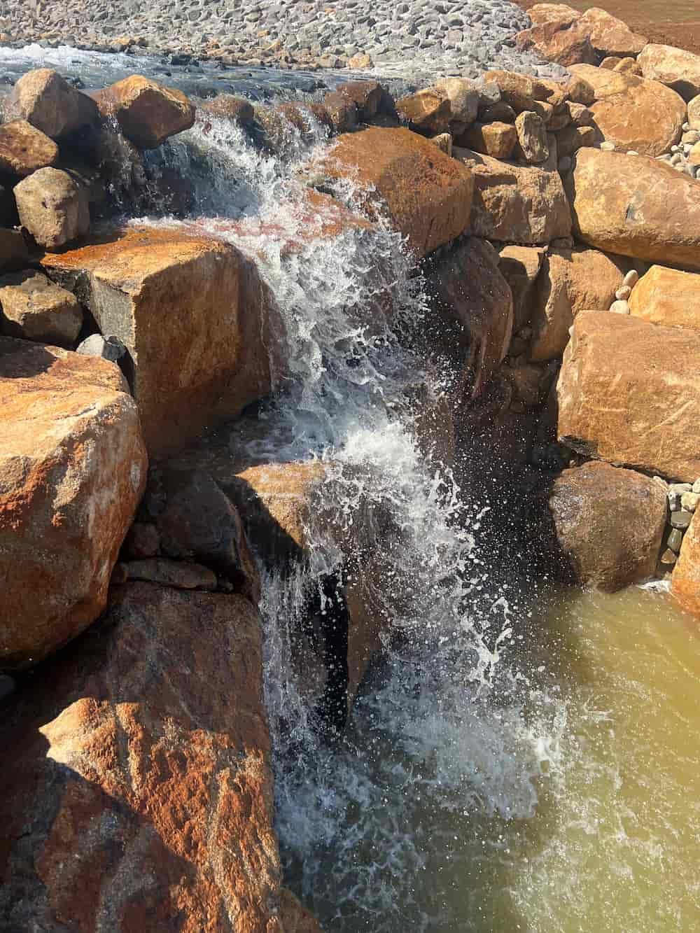 A Small Waterfall Is Surrounded By Rocks And Water — J & M Bashforth & Sons In Brunswick Heads, NSW