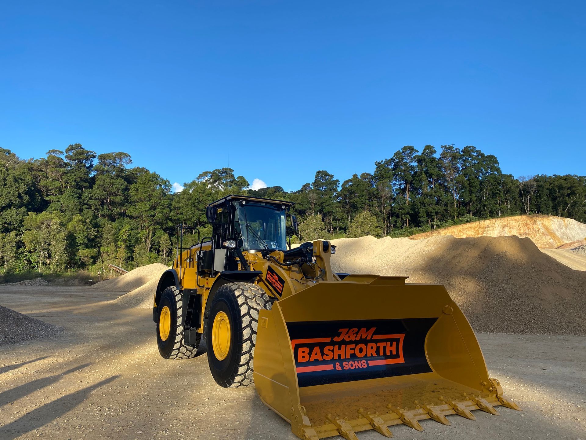 Orange Excavator Parked On A Road  — J & M Bashforth & Sons In Brunswick Heads, NSW