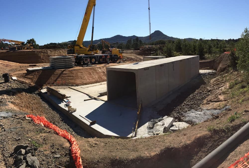 A Yellow Crane Is Lifting A Large Concrete Block — J & M Bashforth & Sons In Brunswick Heads, NSW