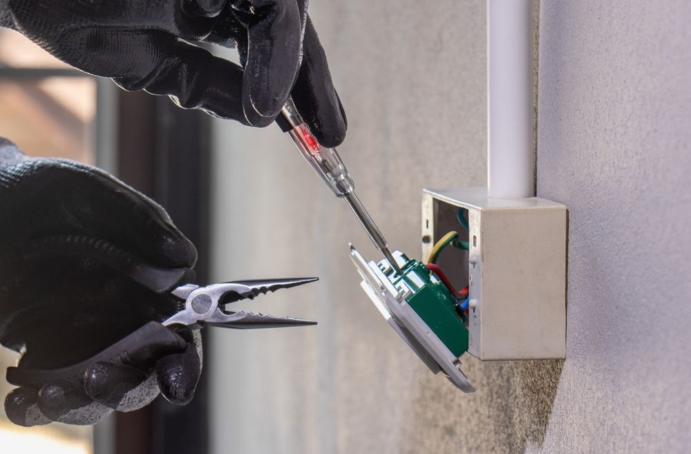 Person Wearing Black Gloves — A Step Above Electrical & Air Conditioning In Edmonton, QLD
