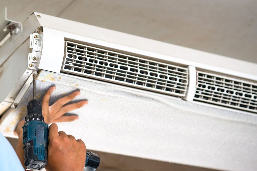 Person Using a Power Drill to Install an Air Vent in a Ceiling — A Step Above Electrical & Air Conditioning In Edmonton, QLD