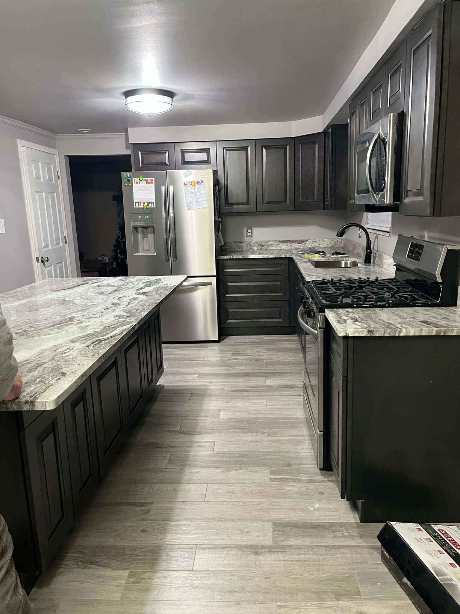 Grey kitchen remodel with dark cabinets, beautiful patterned granite countertops and new stainless steel appliances