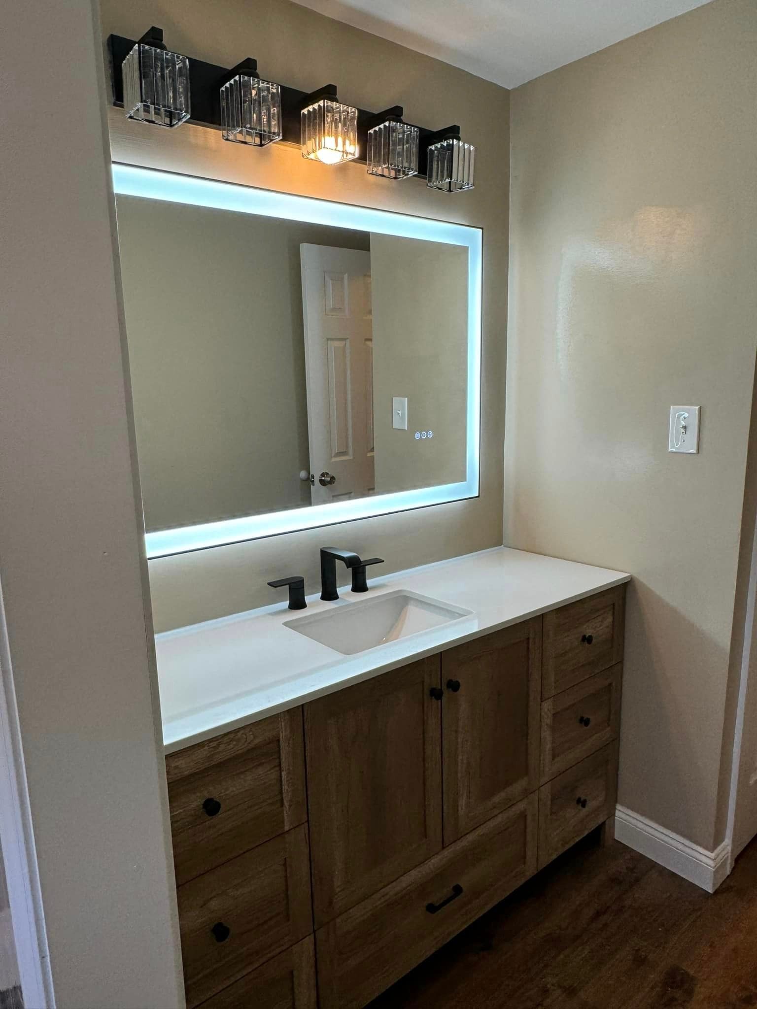 bathroom remodel with new mirror and new cabinets and sink