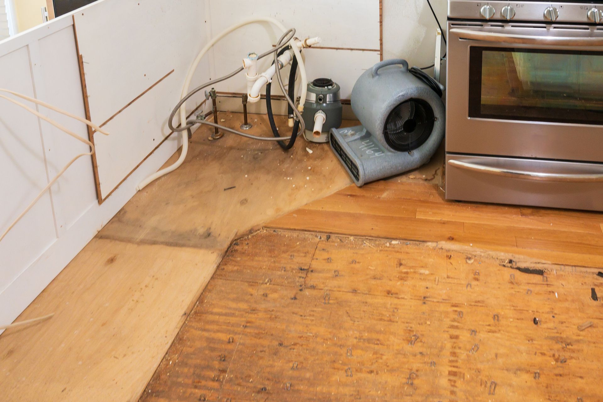 high powered fan drying out flooring underlayment after a plumbing accident