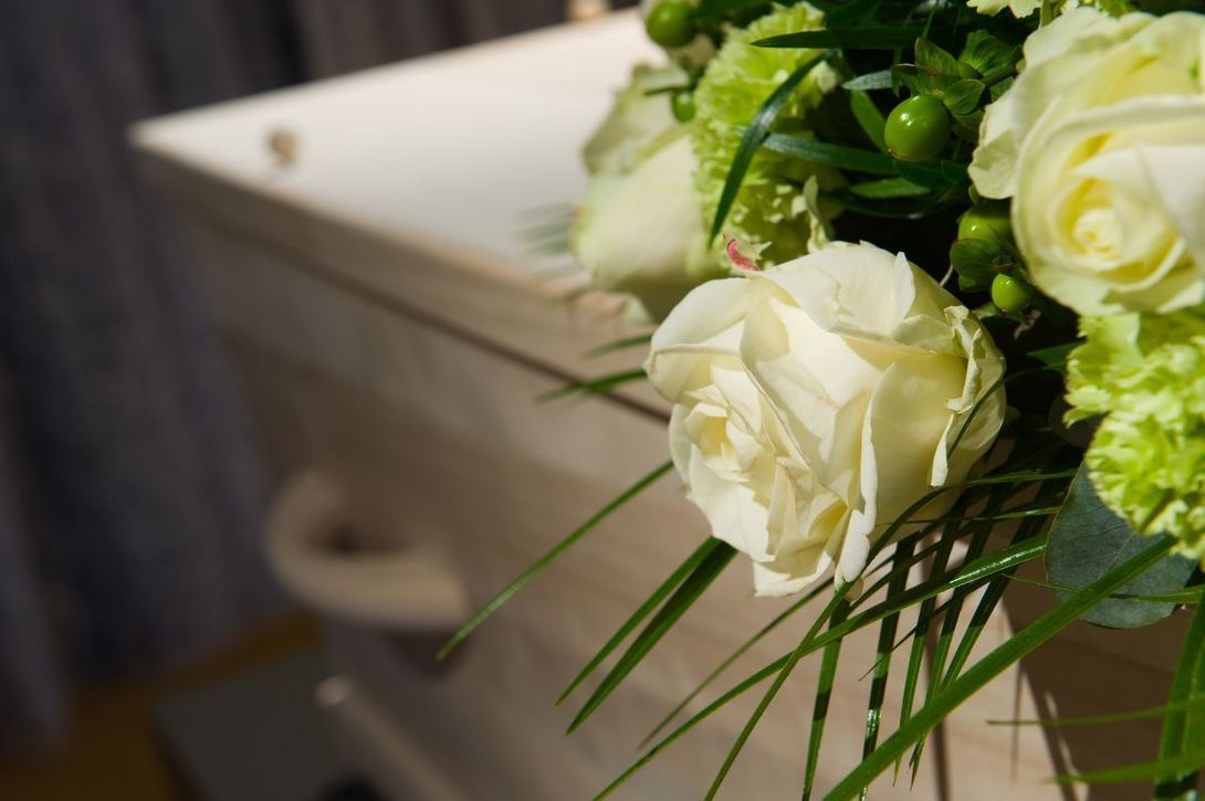 cofano funebre e rosa bianca