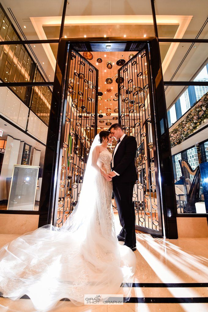 A bride and groom are kissing in an elevator in a building.