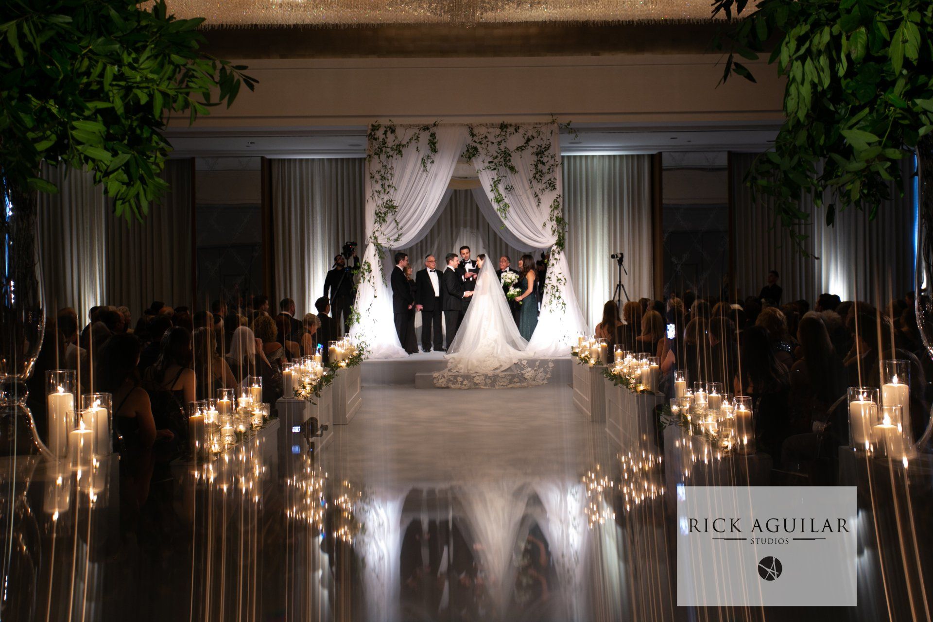 A bride and groom are standing in front of a crowd at a wedding ceremony.
